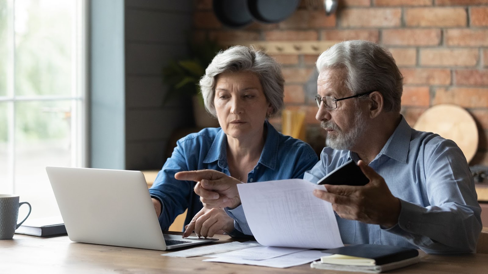 A senior couple doing their taxes together on a laptop.