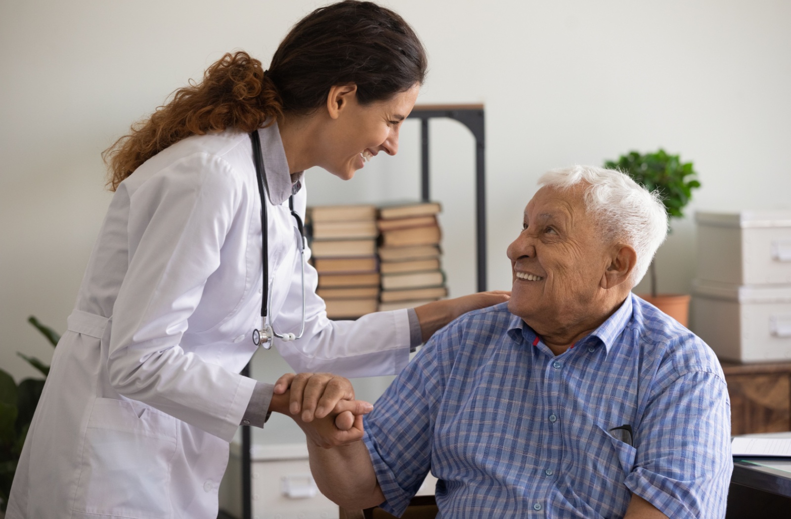 An older adult with dementia in memory care smiling up at a caregiver.