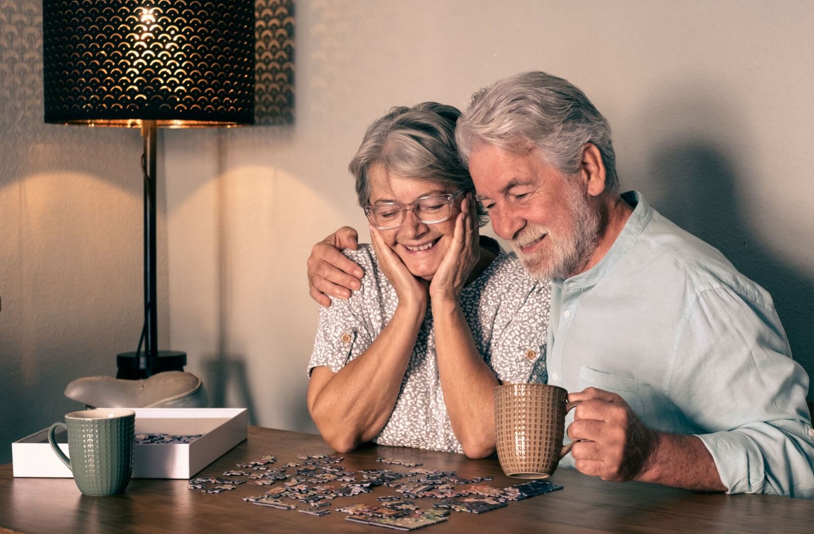 A senior couple work on a puzzle together at home as a healthy habit to support mental sharpness